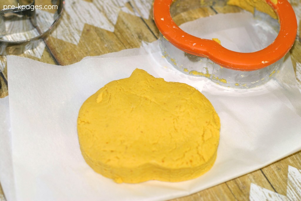 pumpkin play dough cut into pumpkin shape using cookie cutter