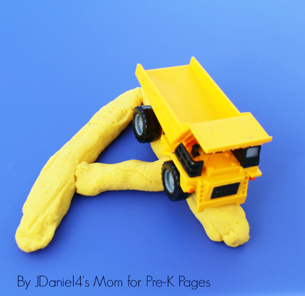 Dumptruck rolling over the letter A made of play dough