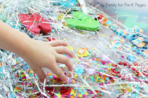 child looking for items in alphabet adventure sensory bin