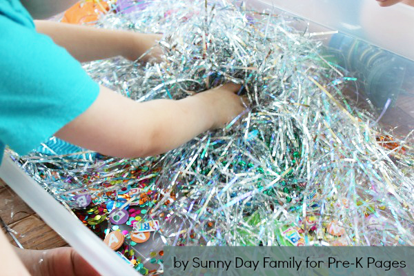 child playing in alphabet sensory bin
