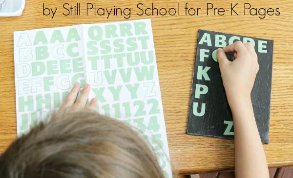 child sticking alphabet stickers on to project
