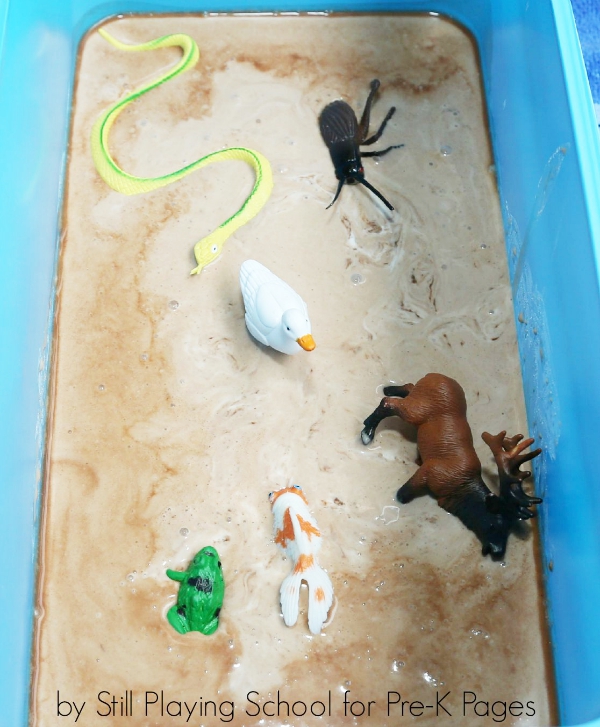 toy animals in muck bin for sensory play