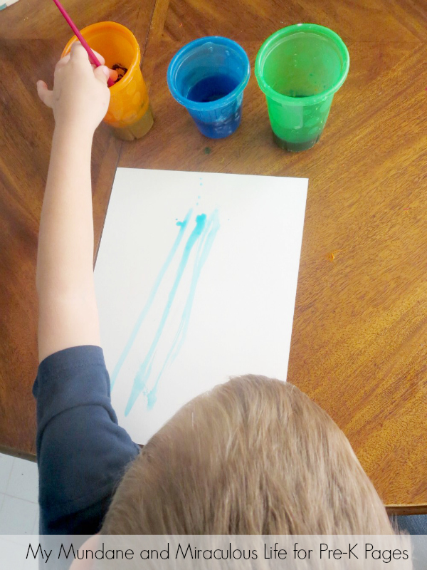 dipping paintbrush in paint cup for weather art