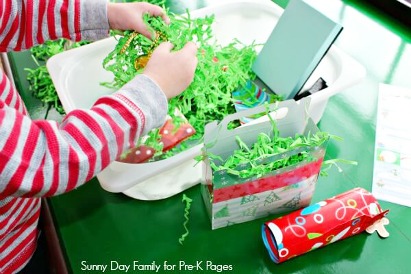 child playing in gift wrap sensory bin