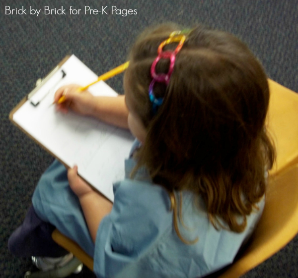 child writing on doctor form on clipboard