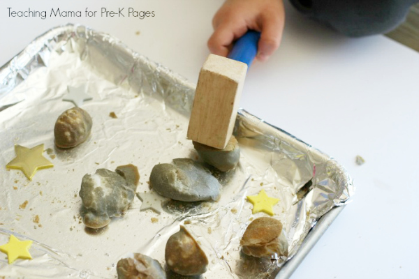 child smashing moon rocks with a mallet