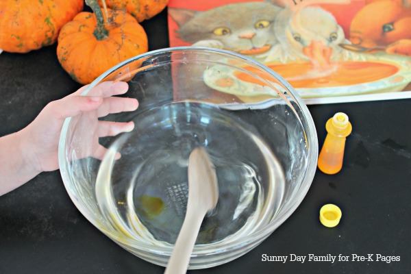 wooden spoon stirring pumpkin soup