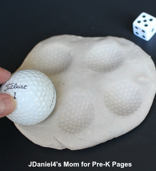 pressing golf ball into playdough