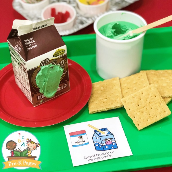 Milk Carton Gingerbread House being assembled with frosting