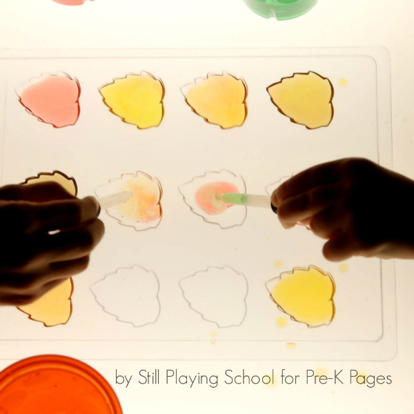 filling fall leaves on light table with colorful water from eyedroppers