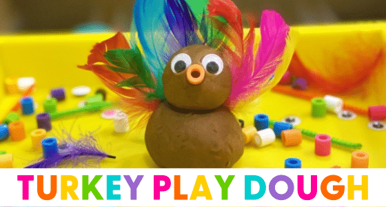 brown playdough used to create a turkey using beads and feathers