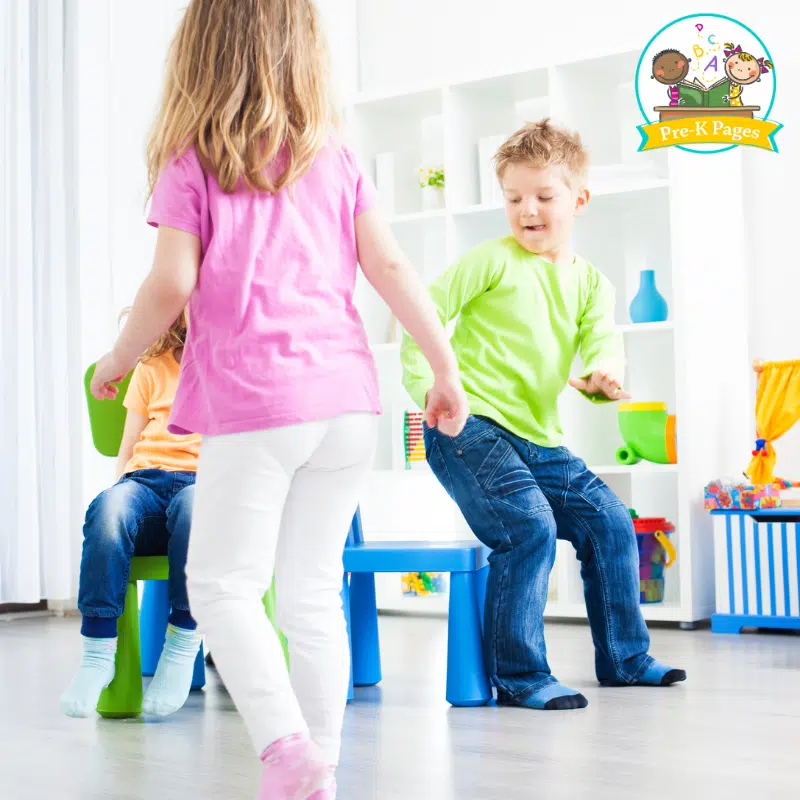 preschool children running around a circle of chairs