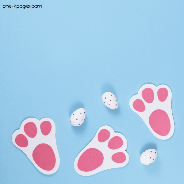 paper bunny footprints and easter eggs laying on table