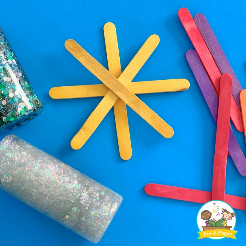 colorful craft sticks and bottles of glitter scattered on tabletop